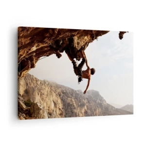 Impression sur toile - Image sur toile - Un grimpeur sur une falaise abrupte dans les montagnes au soleil - 70x50cm - Le monde rétréci dans une main sur une coupe de rocher - Décoration murale moderne pour le salon et la chambre ARTTOR