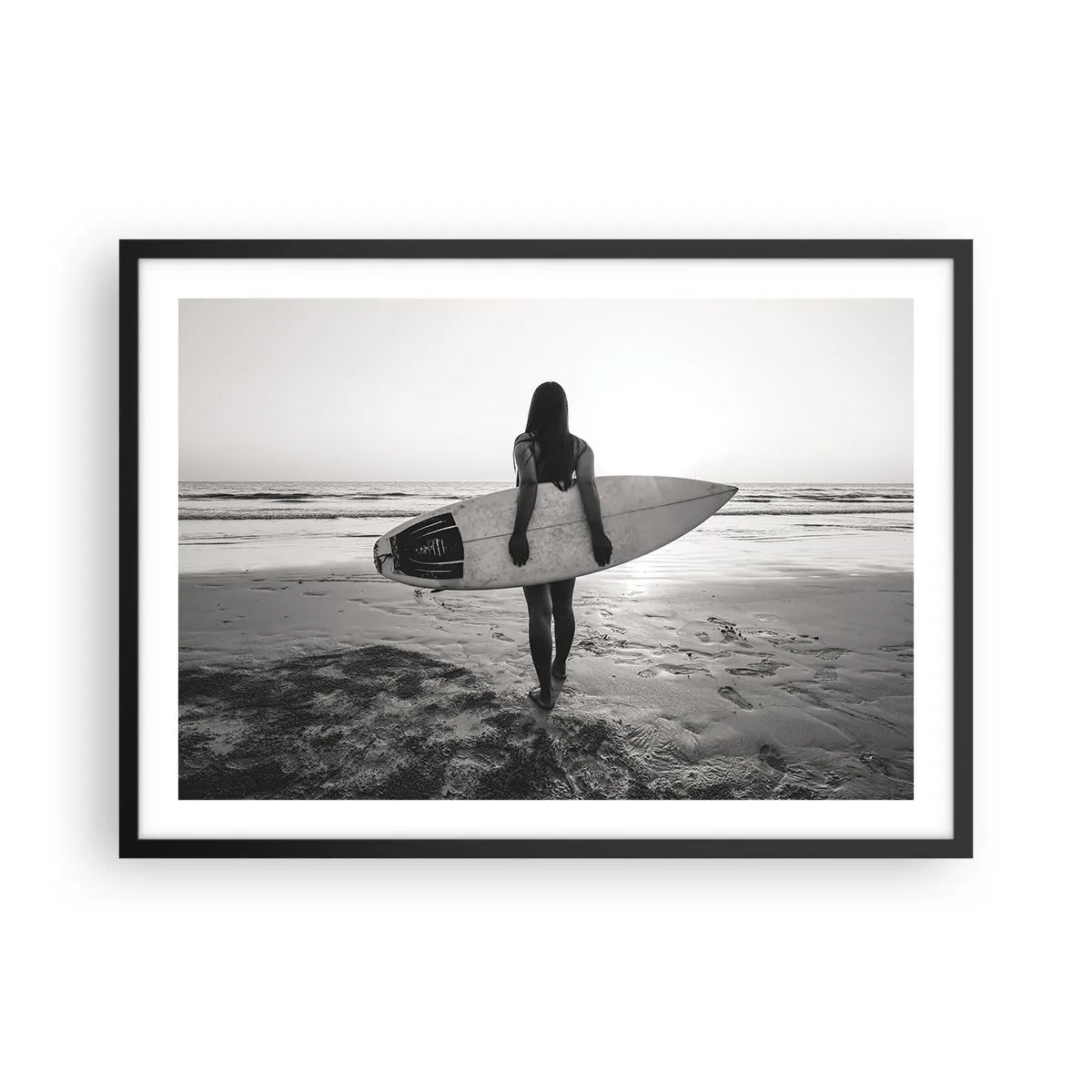 Affiche dans un cadre noir - Poster - Femme avec planche de surf sur la plage en noir et blanc - 70x50cm - Fille des vagues de la mer - Décoration murale moderne pour le salon et la chambre ARTTOR
