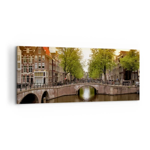 Impression sur toile - Image sur toile - Un canal à Amsterdam entouré d'immeubles historiques - 120x50cm - En bateau ou à vélo ? - Décoration murale moderne pour le salon et la chambre ARTTOR