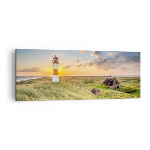Impression sur toile - Image sur toile - Un phare avec des prairies et des maisons au soleil en arrière-plan - 140x50cm - Entre les vagues - Décoration murale moderne pour le salon et la chambre ARTTOR