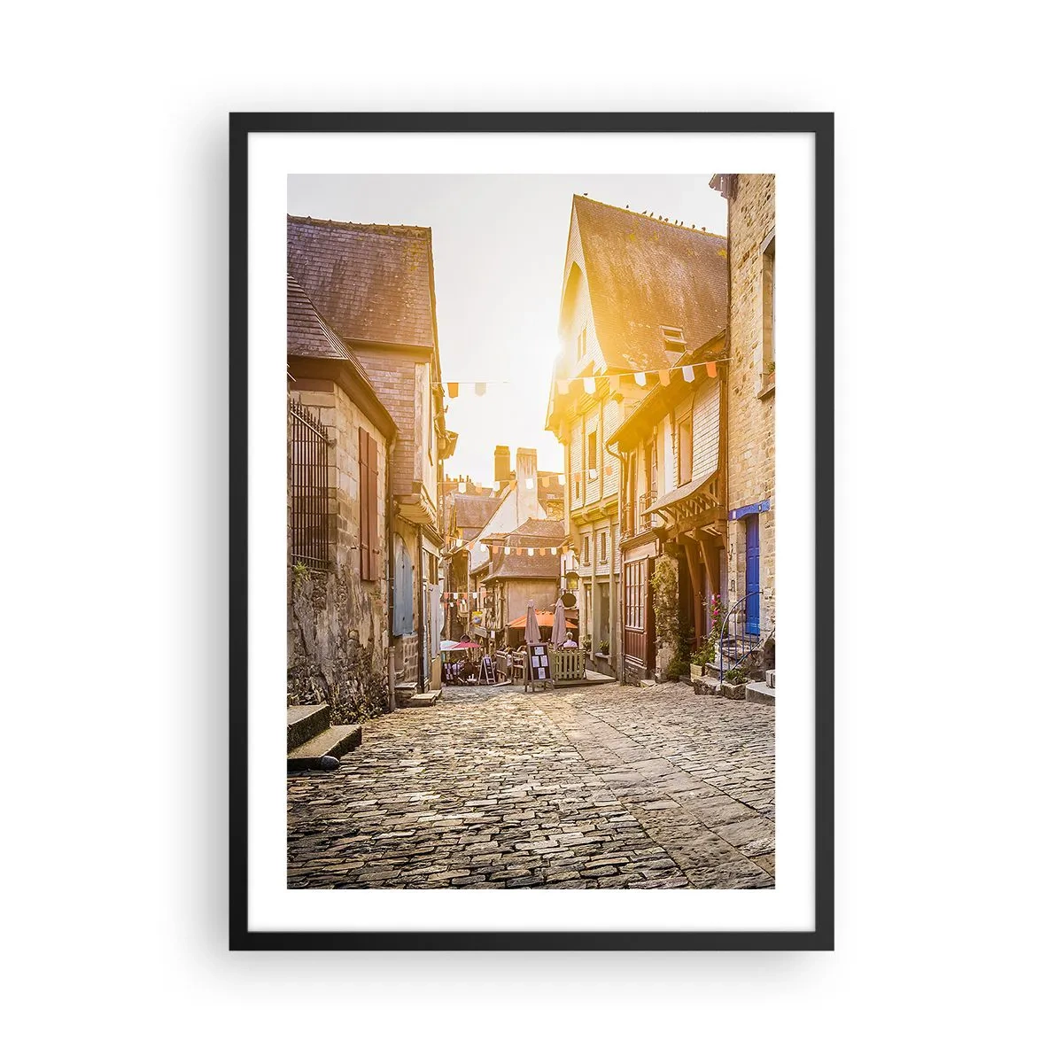Affiche dans un cadre noir - Poster - Une charmante rue avec des immeubles sous les rayons du soleil couchant - 50x70cm - Aux confins du monde - Décoration murale moderne pour le salon et la chambre ARTTOR