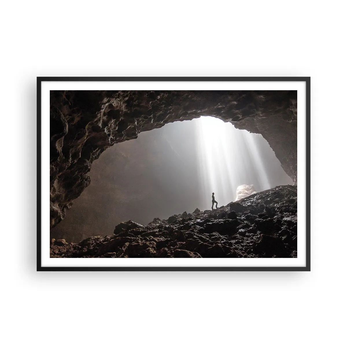 Affiche dans un cadre noir - Poster - Une figure dans une grotte éclairée par des rayons de lumière - 100x70cm - Grotte lumineuse - Décoration murale moderne pour le salon et la chambre ARTTOR