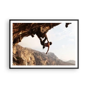 Affiche dans un cadre noir - Poster - Un grimpeur sur une falaise abrupte dans les montagnes au soleil - 100x70cm - Le monde rétréci dans une main sur une coupe de rocher - Décoration murale moderne pour le salon et la chambre ARTTOR