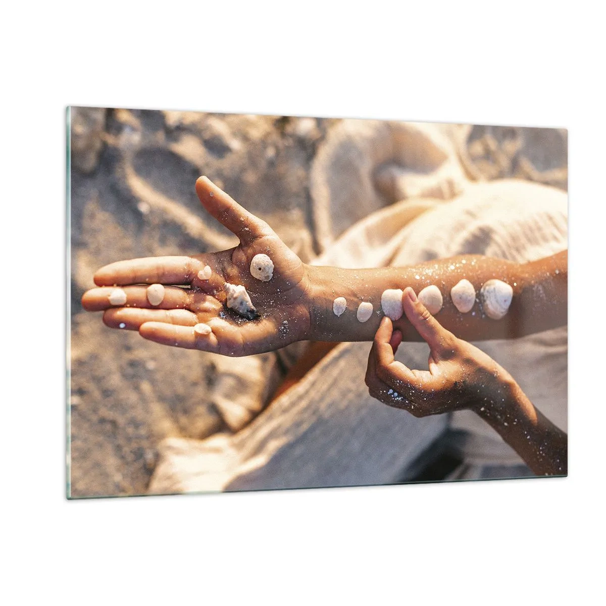 Impression sur verre - Image sur verre - Mains d'enfant avec des coquillages sur un fond de sable et de tissu - 120x80cm - La beauté à portée de main - Décoration murale moderne pour le salon et la chambre ARTTOR