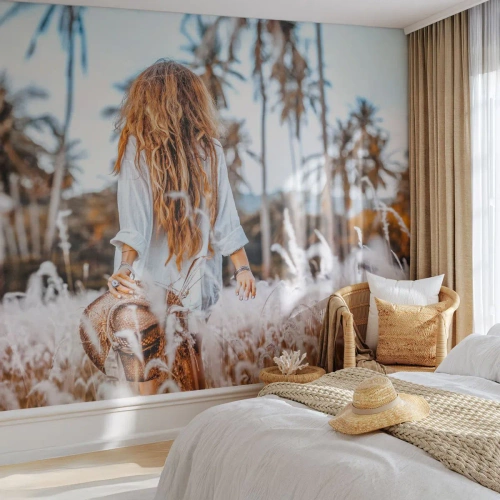 Papier Peint Photo Premium Sand - Une femme parmi l'herbe dans un paysage bordé de palmiers - 100x70cm - Né de peluches d'herbe - Décoration murale moderne pour le salon et la chambre ARTTOR
