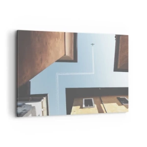 Impression sur toile - Image sur toile - Vue de l'avion et de sa traînée dans le ciel depuis une perspective de rue - 100x70cm - Au-dessus du labyrinthe de la ville - Décoration murale moderne pour le salon et la chambre ARTTOR